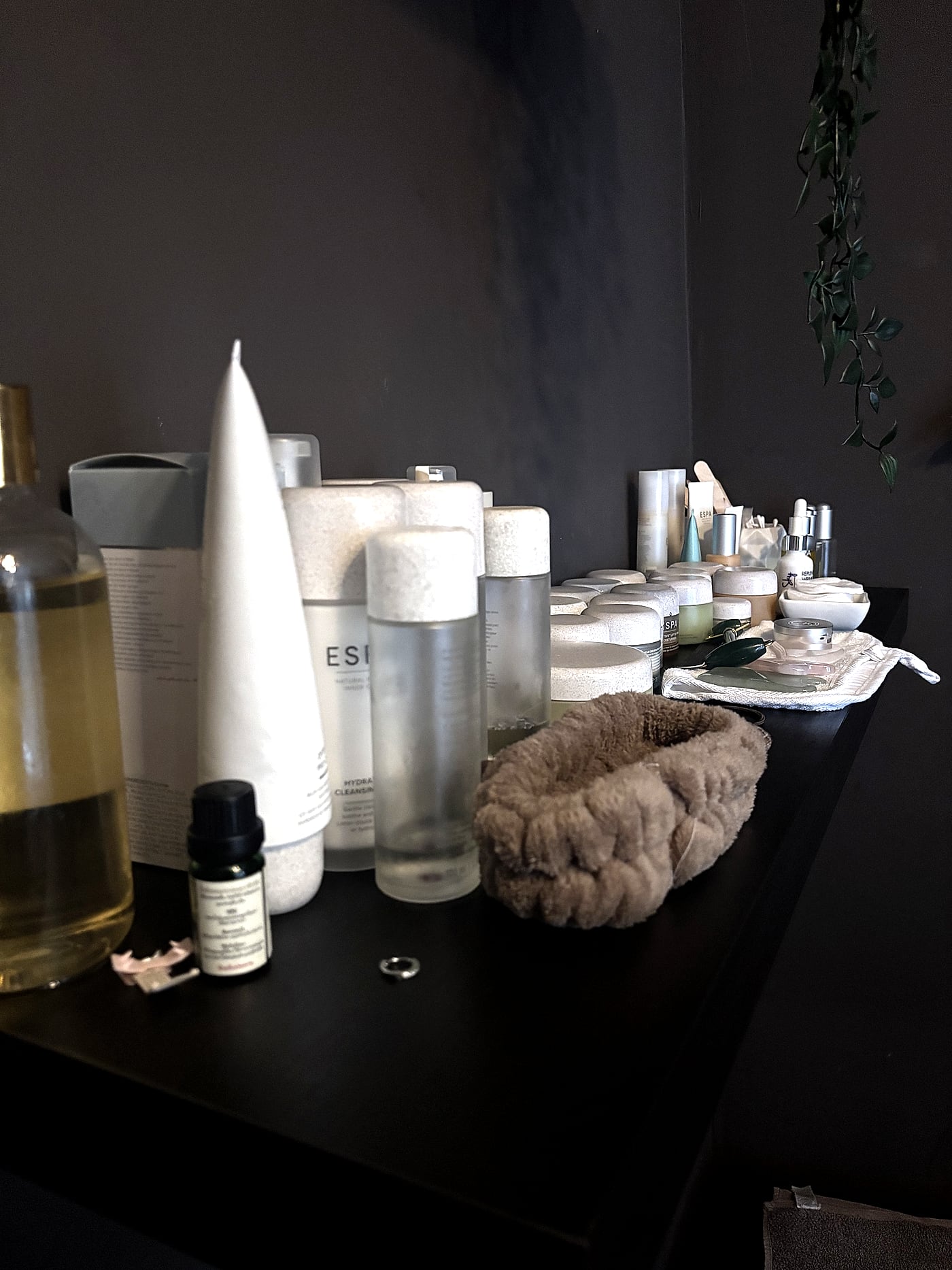 A shelf of ESPA skincare products, oils, a jade roller and a gua sha stone used for facial treatments